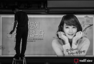 Home arreglant rètol publicitari al metro de Seül